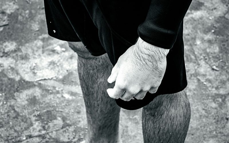 Chalked hand resting on a knee, black and white