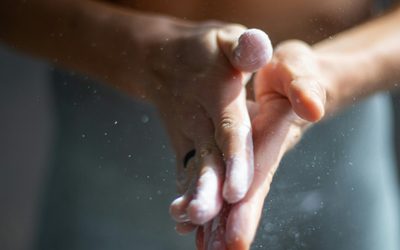 Chalk dust drifting from an athlete's clapped hands