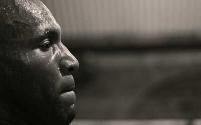 Side profile of an athlete's sweat-covered face, black and white