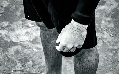 Chalked hand resting on a knee, black and white