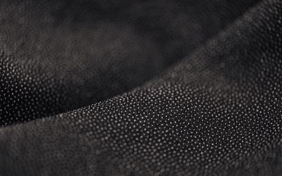 Folds of black textured fabric in low light