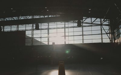 Empty sports hall backlit by a large window, one marker casting a long shadow